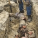 Man digging up a homes damaged sewer pipe