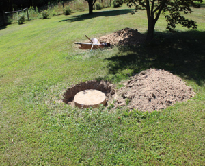 Green lawn with holes dug to expose septic tank lids during a septic inspection