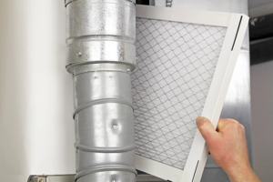 Homeowner changing a furnace filter