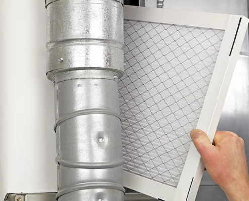 Homeowner changing a furnace filter