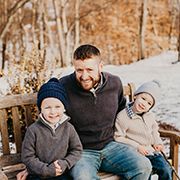 Home Inspector Arthur Duhaime on a bench with his 2 sons